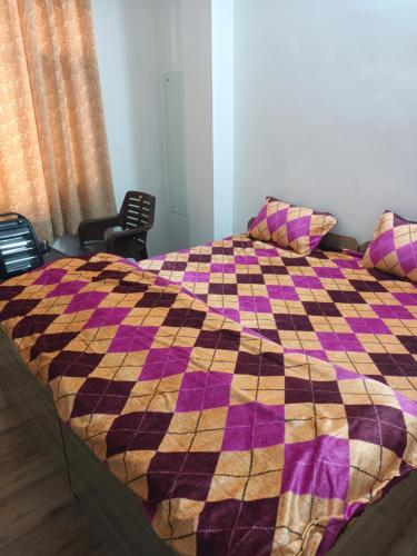 西姆拉Him Aaranya Home stay Shimla的床上有条条纹毯子