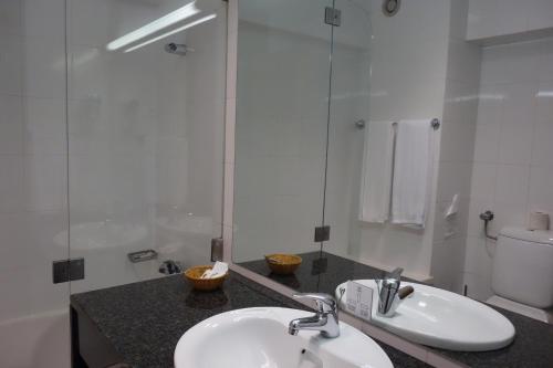 曼瓜尔迪圣母堡酒店的一间带水槽、卫生间和镜子的浴室
