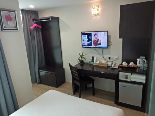 Juru7 Hotel的酒店客房设有一张桌子和一台墙上的电视。