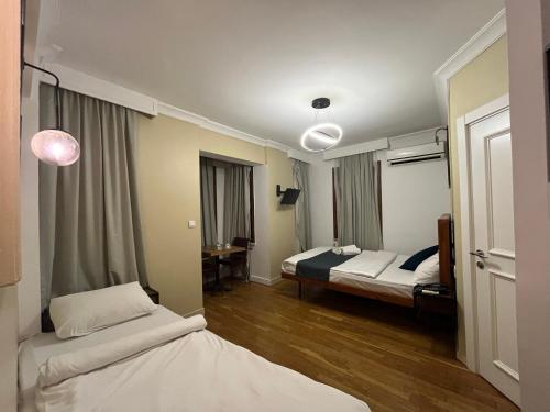 伊斯坦布尔Volga Rika Hotel的酒店客房配有两张床和一张书桌