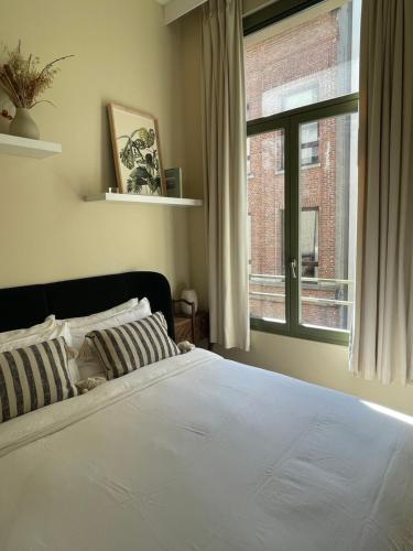 安特卫普Stunning apartment by MAS的一间卧室设有一张床和一个大窗户