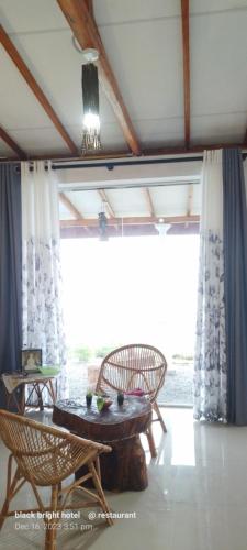 埃拉Black Bridge View Cottage的客房设有桌椅和大窗户。