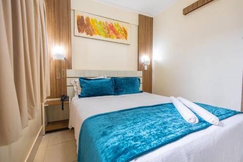 卡达斯诺瓦斯LACQUA DIROMA III - BVTUR的一间卧室配有一张带蓝色枕头的大床