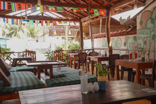 阿鲁甘湾Chimaca Bay Hotel的一间空餐厅,配有木桌和椅子