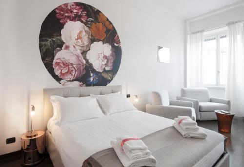 米兰DUOMO VIEW - 2 min from Duomo Amazing location的卧室配有一张白色大床,墙上挂有绘画作品