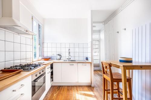 波尔多Beautiful apartment in Bordeaux with garden的厨房配有白色橱柜和炉灶烤箱。