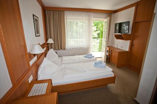 法克湖Seevilla Wochinz的卧室配有一张大白色床和窗户