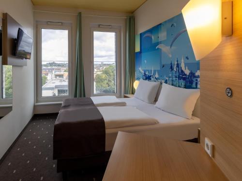 富尔达B&B Hotel Fulda-City的酒店客房设有一张大床和窗户。