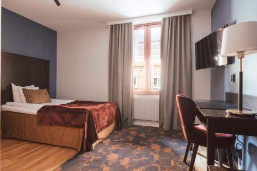 特罗尔海坦西贡奥斯卡克拉丽奥连锁酒店的配有一张床和一张书桌的酒店客房