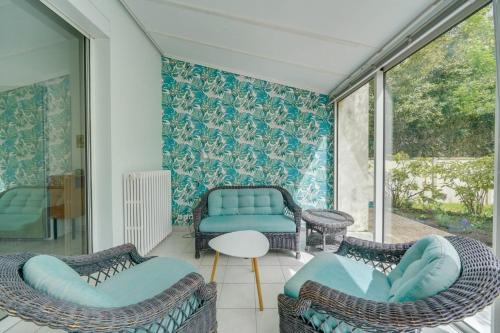 勒布斯卡Jolie maison au Bouscat avec jardin的一间带椅子、一张沙发和一张桌子的房间
