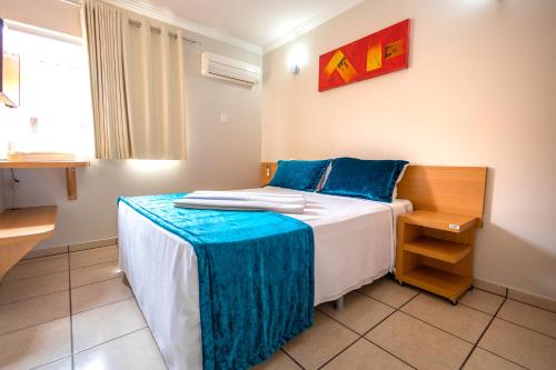 卡达斯诺瓦斯DiRoma Fiori Hotel - BVTUR的一间卧室配有一张带蓝色枕头的床