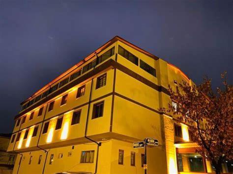 安卡拉ANİMOS BUTİK OTEL的上面有灯的黄色建筑
