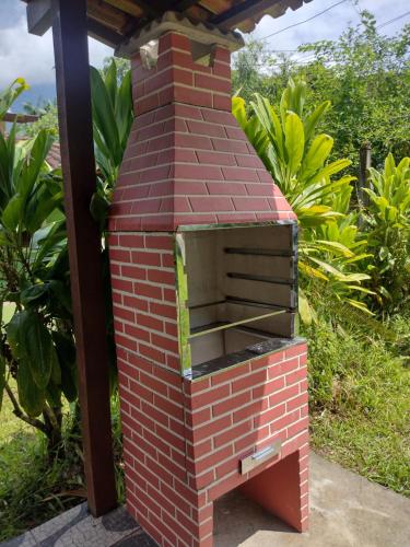 帕拉蒂Casa praias de São Gonçalo em Paraty RJ的坐在花园中的室外砖炉