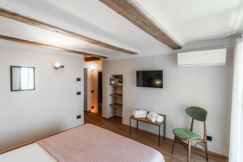 圣马力诺Casa Cicetta的一间卧室配有一张床、一把椅子和电视。