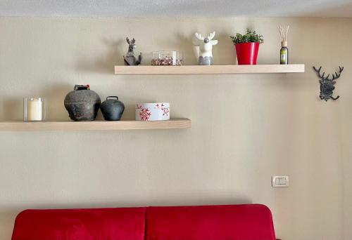 BreuilAlpine Studio with Garage的客厅设有书架、花瓶和红色沙发