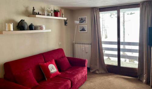 BreuilAlpine Studio with Garage的客厅里一张红色的沙发,配有滑动玻璃门