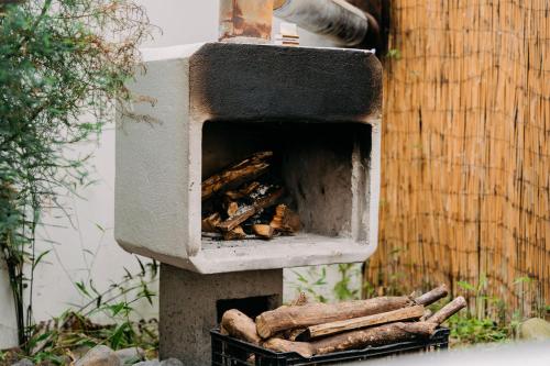 埃雷迪亚Casa Vistas del Conde的户外烤箱,里面堆满了木头