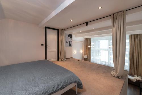 维尔纽斯Spacious & Cozy loft Near Old Town的一间卧室设有一张床和一个大窗户