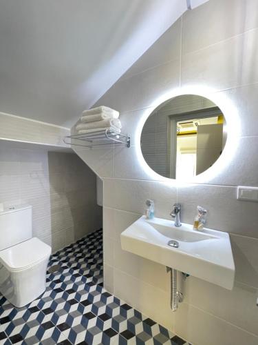 贝莱斯La Villa del Sastre的一间带水槽、卫生间和镜子的浴室