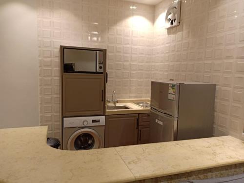 塔伊夫Dorm Story For Hotel Apartment的厨房配有冰箱、洗衣机和烘干机