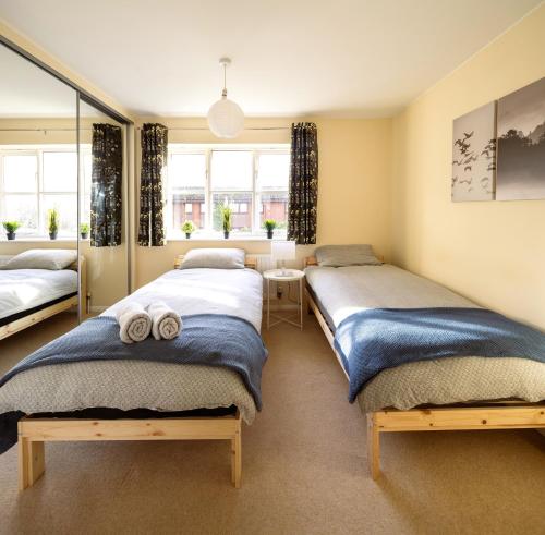吉尔福德Guildford Townhouse with Parking的一间卧室配有两张床和镜子