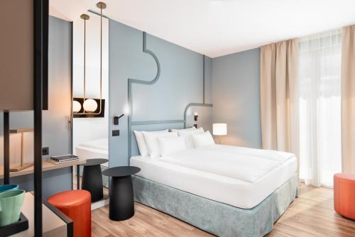 格拉迪斯卡迪松佐HT Hotel Trieste的配有一张床和一张书桌的酒店客房