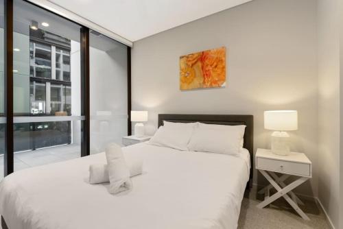 布里斯班1BR Luxury apt at prime location w carpark的卧室设有一张白色大床和一扇窗户。