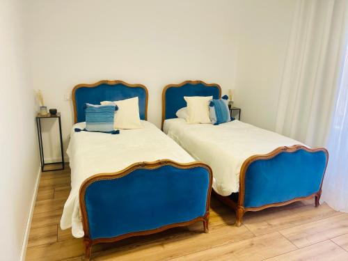 卡尔卡松La Belle Etape à Carcassonne的客房内的两张床和蓝色椅子