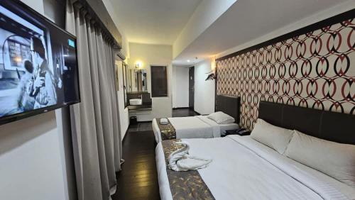 哥打京那巴鲁Warisan Hotel Kota Kinabalu的酒店客房设有两张床和一台平面电视。