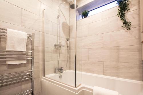 伯肯黑德Brattan House Oxton Wirral 5 bedroom 3 bathroom with on-street parking ideal for vans by Rework Accommodation的带淋浴、浴缸和盥洗盆的浴室