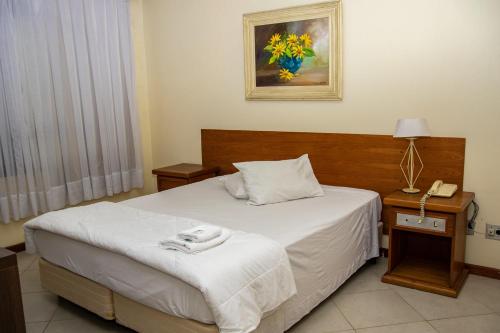 格拉瓦塔伊Hotel Radar的酒店客房配有一张床和电话