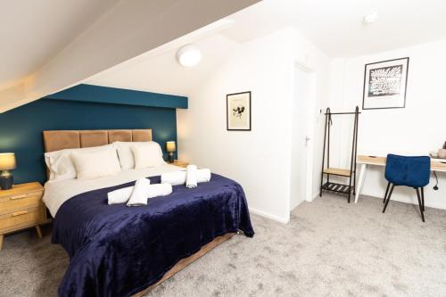 奥尔德姆Suite 6 - Double Room in the Heart of Oldham的一间卧室设有一张蓝色墙壁的大床