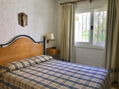 埃斯特角城Casa de 6 ambientes a 2 cuadras de la playa brava的一间卧室配有一张带铺着地毯的床和窗户。