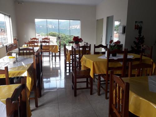 伊比科阿拉Hotel Raio do Sol的餐厅设有桌椅和黄色桌布