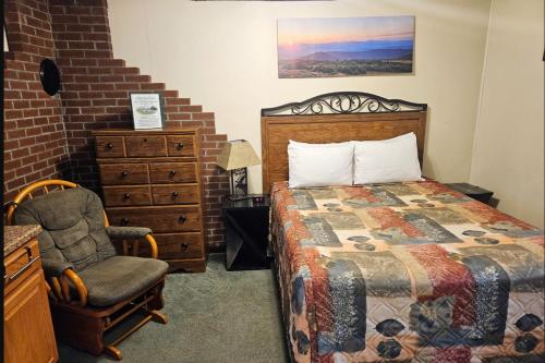 林肯Riverbank Motel and Cabins Managed by Vacasa的一间卧室配有一张床和一把椅子
