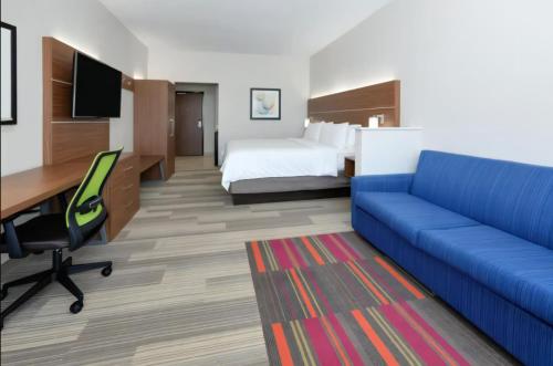 普利茅斯Holiday Inn Express - Minneapolis West - Plymouth, an IHG Hotel的酒店客房,配有床和蓝色的沙发