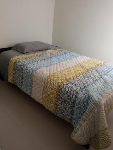 Gallinazos HaciendaCasa Villa Eru的床上有五颜六色的毯子