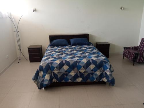 Gallinazos HaciendaCasa Villa Eru的卧室配有蓝色和白色的床和椅子