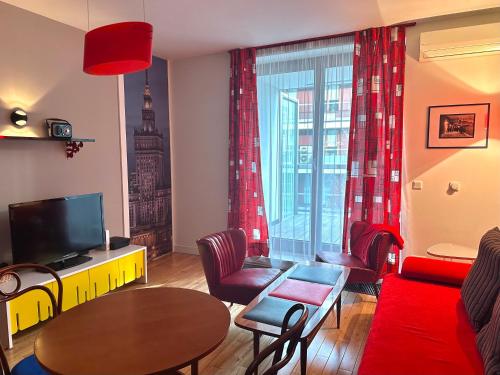 华沙Project Comfort Leszczyńska 4/33 Warszawa的客厅配有红色的沙发和桌子