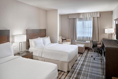 艾尔德里Fairfield Inn & Suites by Marriott Airdrie的酒店客房配有两张床和一张书桌