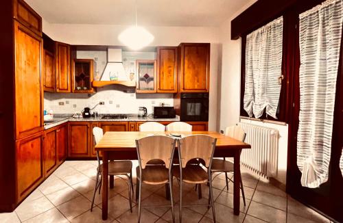 圣古利亚Casa Giulia的厨房配有木桌和椅子