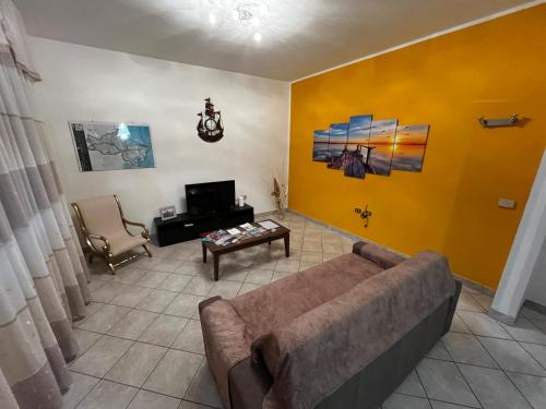 圣古利亚Casa Giulia的带沙发和黄色墙壁的客厅