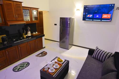 希克杜沃Monkey Island Hotel的带沙发的厨房和墙上的电视
