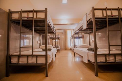 科伦坡Drop Inn Hostels的客房设有三张双层床,配有白色床单