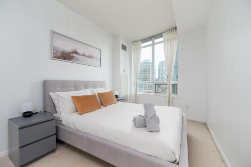 多伦多Fort York Apartments的白色的卧室设有一张大床和一个窗户