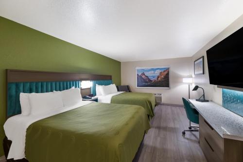 阿尔派恩Quality Inn Alpine的酒店客房设有两张床和一台平面电视。