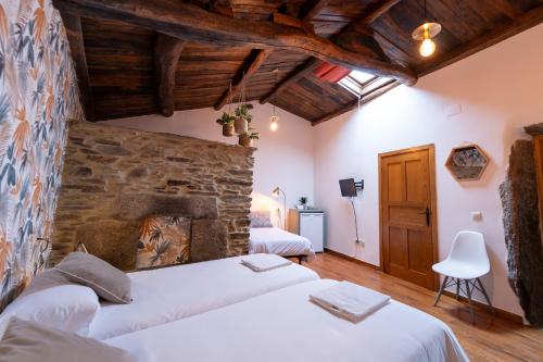 欧德鲁佐Casa Rural Piñeiro, de Vila Sen Vento的一间卧室设有两张床和石墙