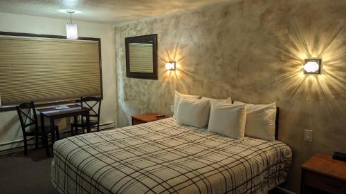 萨利纳High Desert Inn的酒店客房配有一张床铺、一张桌子和一张书桌。