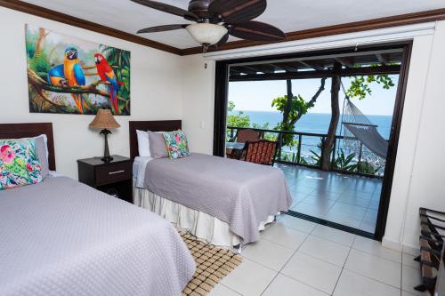 El NísperoParaiso Escondido Hotel Villas & Resort的一间带两张床的卧室,享有海景