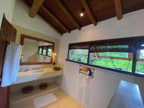 托兰克索Etnia Casa Hotel的一间带水槽和镜子的浴室以及窗户。